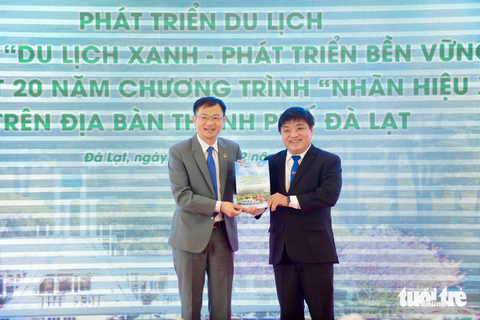 Giải nhất hiến kế: Đi tìm thương hiệu cho Đà Lạt - thành phố của cảm hứng sống- Ảnh 1. Ông Lê Thế Chữ (phải), tổng biên tập báo Tuổi Trẻ, trao tập ghi nhận các "Hiến kế phát triển du lịch Đà Lạt bền vững" cho ông Đặng Quang Tú, chủ tịch UBND TP Đà Lạt - Ảnh: QUANG ĐỊNH