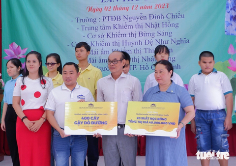 Đại diện các đơn vị trao học bổng và gậy dò đường cho người mu - Ảnh: DIỆU LINH Đại diện các đơn vị trao học bổng và gậy dò đường cho người mù - Ảnh: DIỆU LINH