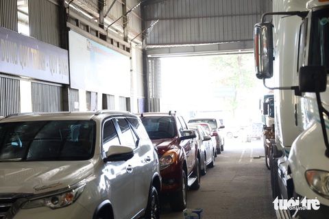 Đăng kiểm cuối năm chỗ đông nghẹt, nơi vắng vẻ- Ảnh 2. Đến 13h30, 40 - 50 ô tô và container vẫn chờ đợi, nhiều tài xế ngao ngán vì đã đợi từ sáng sớm tới trưa vẫn chưa thể vào kiểm định - Ảnh: NGỌC QUÝ
