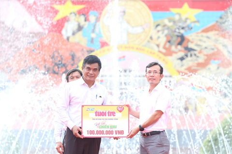 'Về lại chiến khu' căn cứ Trung ương Cục miền Nam- Ảnh 4. Nhà báo Trần Xuân Toàn, phó tổng biên tập báo Tuổi Trẻ, đại diện báo trao ủng hộ 100 triệu đồng cho quỹ “Chung một tấm lòng” - Ảnh: CẨM NƯƠNG