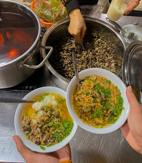 Bánh đúc nóng, bánh trôi tàu, phở sưởi ấm mùa đông Hà Nội- Ảnh 3. Bánh đúc nóng được múc ngay khi thực khách đến quán và được ăn kèm với nhân thịt băm, mộc nhĩ, nấm hương, hành lá… và nước dùng để cân bằng vị - Ảnh: QUỐC NAM