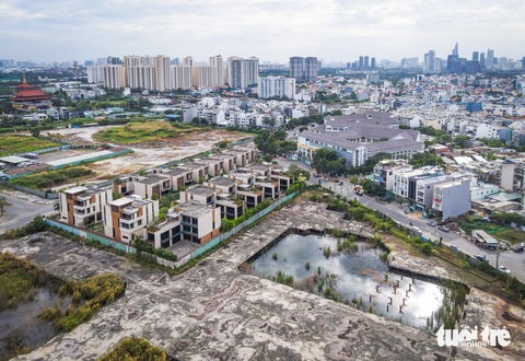 TP.HCM nhiều lần nhắc nhở, đường sá hai khu đô thị tỉ đô vẫn ‘tắc’ sau hơn hai thập kỷ- Ảnh 2. Hạ tầng, đường sá trong khu đô thị An Phú - An Khánh vẫn lởm chởm da beo, nhiều khu đất trống, đọng nước được hàng rào tôn quây kín trong thời gian dài