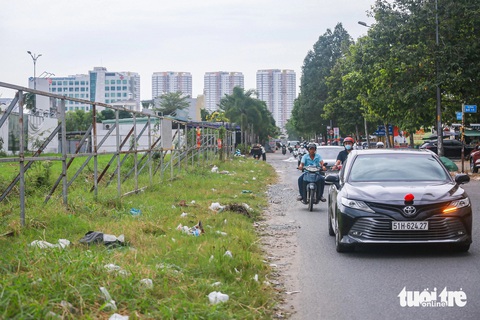 TP.HCM nhiều lần nhắc nhở, đường sá hai khu đô thị tỉ đô vẫn ‘tắc’ sau hơn hai thập kỷ- Ảnh 5. Đường Nguyễn Hoàng mới được làm hơn 17m ở bên phía khu đô thị An Phú - An Khánh, phần còn lại gần 20m, theo kế hoạch do khu đô thị An Phú làm, nhưng 20 năm qua vẫn vậy. Con đường nay thường xuyên rơi vào tình trạng bong tróc, chi chít ổ gà, ổ voi khiến người dân lắc đầu ngao ngán