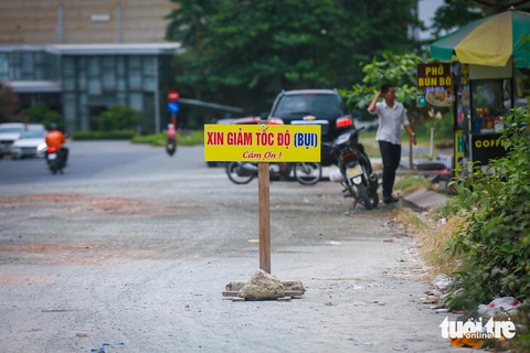TP.HCM nhiều lần nhắc nhở, đường sá hai khu đô thị tỉ đô vẫn ‘tắc’ sau hơn hai thập kỷ- Ảnh 7. Một số đường nội khu đô thị còn là đường đất. Do đó, người dân phải cắm tạm bảng thông báo xin giảm tốc độ vì... bụi