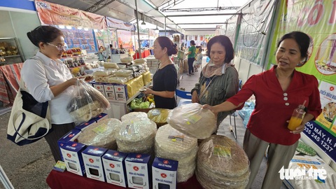 Người dân TP.HCM sắm Tết với hàng nghìn đặc sản đến từ 45 tỉnh, thành- Ảnh 1. Nhiều loại bánh tráng đặc sản của Bình Định như bánh tráng gạo, bánh tráng dừa... được người bán giới thiệu đến khách hàng - Ảnh: N.TRÍ