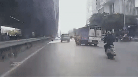 Công an phát thông báo tìm tài xế xe tải chèn ngã 2 người trên xe máy ở Hà Nội- Ảnh 1. Cảnh chiếc xe tải chèn ngã 2 người trên chiếc xe máy - Ảnh: D.A.