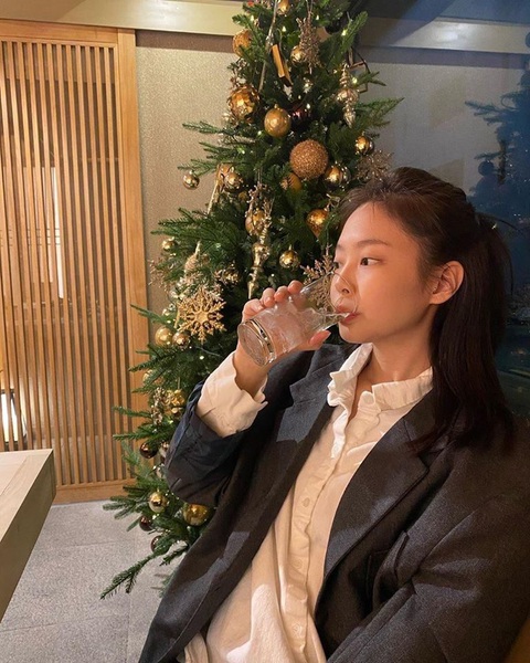 Jennie gợi ý chụp ảnh Giáng sinh kiểu 'ai không xinh thì xấu'- Ảnh 2. Ở một góc ảnh khác, nữ idol cầm ly uống nước và khoe không khí Giáng sinh bên cây thông. Cư dân mạng kiểu: