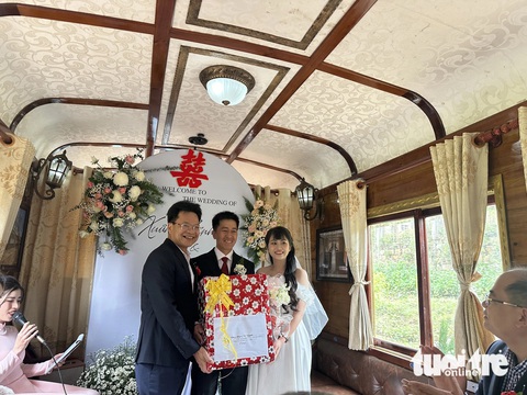 Độc đáo tiệc cưới tổ chức trên tàu cổ tuyến Đà Lạt - Trại Mát- Ảnh 5. Ông Đặng Sỹ Mạnh - chủ tịch HĐTV Tổng công ty Đường sắt Việt Nam - tặng hoa cho cô dâu chú rể - Ảnh: LÊ ANH TUẤN