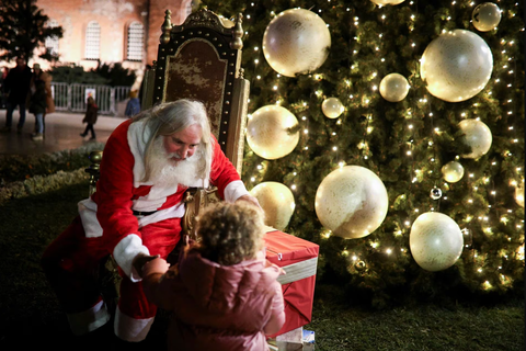Ông già Noel cưỡi xe máy, lên rừng xuống bể phát quà Giáng sinh- Ảnh 13. Một ông già Noel với vẻ ngoài giống hệt mô tả trong truyền thuyết trò chuyện với trẻ nhỏ cạnh cây thông khổng lồ của nhà thờ Alexander Nevsky nằm ở thủ đô Sofia, Bulgaria vào ngày 1-12 - Ảnh: REUTERS