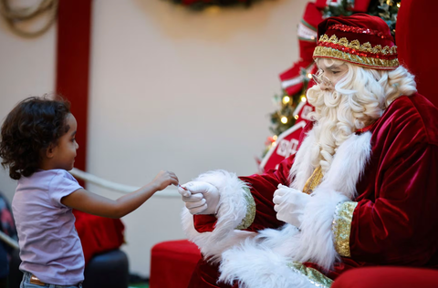 Ông già Noel cưỡi xe máy, lên rừng xuống bể phát quà Giáng sinh- Ảnh 20. Một đứa trẻ thích thú khi nhận được quà từ ông già Noel tại trung tâm mua sắm ở thủ đô Brasilia, Brazil ngày 29-11 - Ảnh: REUTERS