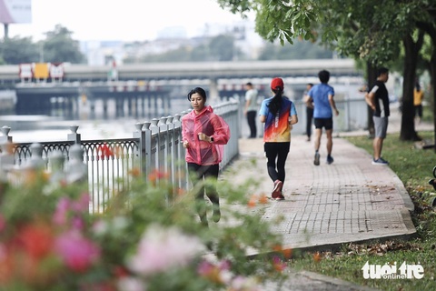 Người dân TP.HCM tận hưởng Giáng sinh trong tiết trời se lạnh- Ảnh 2. Gió lùa se lạnh, người dân tập thể dục ở bờ kè Trường Sa (quận Bình Thạnh) mặc thêm áo khoác - Ảnh: PHƯƠNG QUYÊN