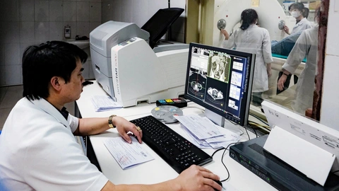 Tế bào ung thư 'khoái' đường ngọt, làm miễn dịch cơ thể yếu đi- Ảnh 1. Các bác sĩ tại một bệnh viện đọc kết quả kiểm tra sức khỏe của bệnh nhân - Ảnh: NAM TRẦN
