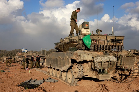 Israel tuyên bố đã tiêu diệt 8.000 chiến binh Palestine- Ảnh 1. Binh sĩ Israel tập trung quanh chiếc xe tăng gần biên giới với Dải Gaza ở miền nam Israel hôm 24-12 - Ảnh: AFP