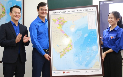 Treo bản đồ Việt Nam: Tình yêu và tự hào chủ quyền Tổ quốc- Ảnh 1. Anh Bùi Quang Huy (trái) trao bản đồ cho học sinh Trường THPT Phan Châu Trinh (Đà Nẵng) - Ảnh: Đ.NHẠN