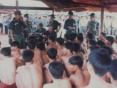 Các tù binh đang ngồi nghe phổ biến quy định trao trả ở phi trường Lộc Ninh - 1973 - Ảnh tư liệu Các tù binh đang ngồi nghe phổ biến quy định trao trả ở phi trường Lộc Ninh - 1973 - Ảnh tư liệu