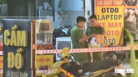 Bắt 2 người trong vụ đâm chết em trai chủ tiệm cầm đồ sau va chạm giao thông- Ảnh 1. Lực lượng chức năng có mặt trước tiệm cầm đồ tối 26-12 - Ảnh: NGỌC KHẢI