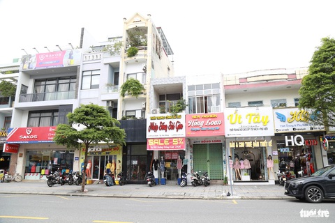Phố thời trang Đà Nẵng giảm giá sâu, bán thêm hàng trái ngành để xoay xở vụ Tết- Ảnh 4. Một dãy shop thời trang nằm im lìm giữa cao điểm mua sắm Tết - Ảnh: ĐOÀN NHẠN