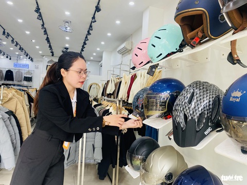 Phố thời trang Đà Nẵng giảm giá sâu, bán thêm hàng trái ngành để xoay xở vụ Tết- Ảnh 8. Shop F. bày thêm kệ bán mũ bảo hiểm để mong thêm nguồn doanh thu trong thời buổi thị trường ảm đạm - Ảnh: ĐOÀN NHẠN