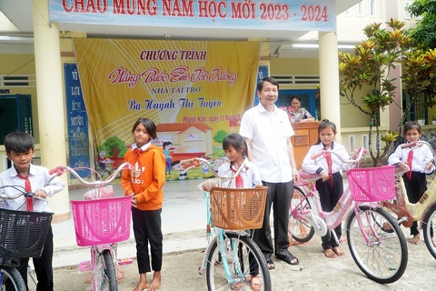 Hậu giấc mơ đào vàng, máu và nước mắt - Kỳ 3: Hồi sinh ngôi làng bị lũ xóa sổ ở xứ vàng- Ảnh 2. Ông Lý Minh Tám trong một lần trao xe đạp cho học sinh ở xã Phước Kim - Ảnh: ĐOÀN CƯỜNG