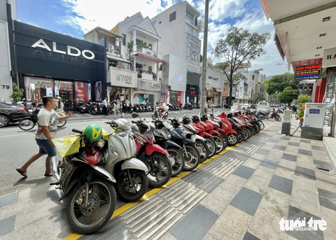9 trường hợp tạm dùng vỉa hè phải đóng phí ở TP.HCM- Ảnh 1. Việc rà soát, tiến hành thu phí sử dụng tạm lòng đường, vỉa hè ở TP.HCM hướng đến quản lý trật tự đô thị tốt hơn. Trong ảnh: xe máy xếp hàng ngăn nắp trong khu vực kẻ vạch để xe tự quản (đường Nguyễn Trãi, quận 1, TP.HCM) - Ảnh: CHÂU TUẤN
