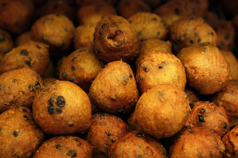 10 món ăn may mắn để đón năm mới- Ảnh 5. Oliebol giống như bánh rán của Việt Nam. Người Hà Lan ăn chúng vào đêm giao thừa. Chúng xuất hiện nhiều tại các hàng ăn đường phố ở đất nước này. Món bánh được làm bằng cách thả một muỗng bột có rắc nho khô vào nồi chiên, sau đó phủ đường bột lên - Ảnh: Getty Images.