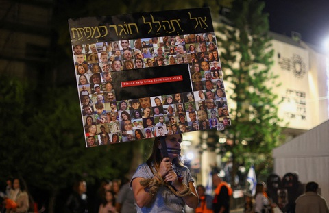Một người biểu tình cầm tấm biển in hình các con tin bị Hamas bắt cóc ở Tel Aviv, Israel, ngày 2-12 - Ảnh: REUTERS Một người biểu tình cầm tấm biển in hình các con tin bị Hamas bắt cóc ở Tel Aviv, Israel, ngày 2-12 - Ảnh: REUTERS