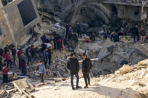 Bộ Quốc phòng Anh gửi máy bay giám sát tìm con tin ở Gaza- Ảnh 2. Người dân bên đống đổ nát sau trận pháo kích đêm 3-12 của Israel nhằm vào thành phố Rafah, miền nam Dải Gaza - Ảnh: AFP