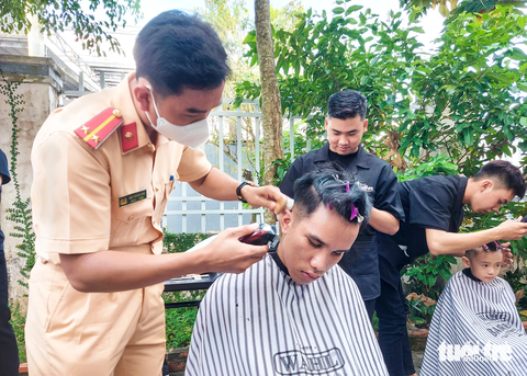 Công an Kiên Giang đọc sách, khám bệnh miễn phí cho người mù- Ảnh 3. Các anh công an làm thợ cắt tóc cho người khiếm thị ở địa phương