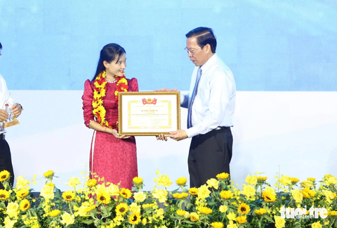 Cô Thu Tắk Pổ nhận giải thưởng Tình nguyện quốc gia 2023- Ảnh 2. Ông Phan Văn Mãi, chủ tịch UBND TP.HCM, trao giải thưởng Tình nguyện quốc gia năm 2023 cho cô giáo Trà Thị Thu - Ảnh: CÔNG TRIỆU