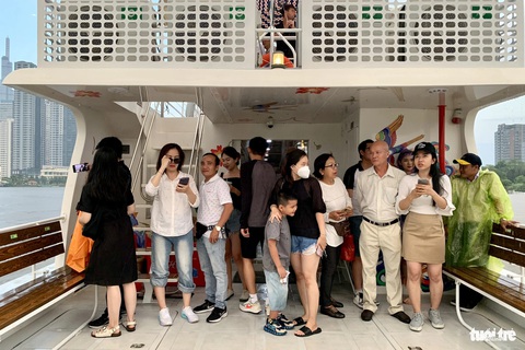Giao thừa này, người Sài Gòn thêm trải nghiệm buýt sông, xem pháo hoa- Ảnh 2. Chuyến buýt sông hai tầng rời bến, hàng chục hành khách cho biết đây là lần đầu tiên thử ngắm mưa trên sông Sài Gòn. Dù vậy, họ mong thời tiết ổn định để lên tầng hai ngắm cảnh, check-in - Ảnh: PHƯƠNG NHI