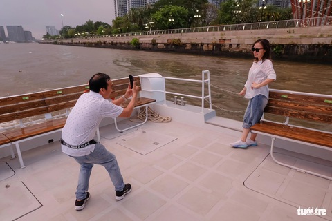 Giao thừa này, người Sài Gòn thêm trải nghiệm buýt sông, xem pháo hoa- Ảnh 5. Vợ chồng chị Vũ Thị Tuyết chụp ảnh, check-in trên tàu buýt sông hai tầng - Ảnh: PHƯƠNG NHI