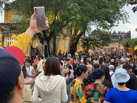 Chưa đến giao thừa mà phố cổ Hội An đã 'ùn ứ' khách- Ảnh 1. Khách ùn ùn từ các hướng đổ về hai bên bờ sông Hoài chiều cuối năm 2023 - Ảnh: B.D.