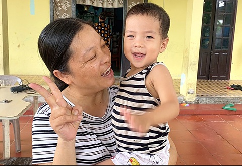 Chị Hồng Đức - người tình nguyện gánh vác công việc thiện nguyện với ông Hùng - bế một trẻ được nuôi dạy ở trung tâm Chị Hồng Đức - người tình nguyện gánh vác công việc thiện nguyện với ông Hùng - bế một trẻ được nuôi dạy ở trung tâm