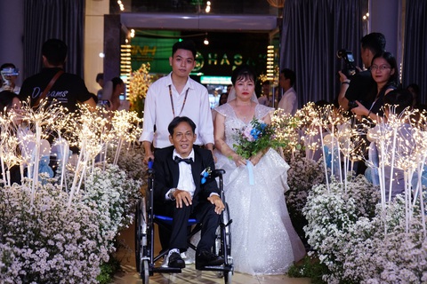 Sinh viên tổ chức lễ cưới trong mơ cho các đôi khuyết tật- Ảnh 1. Cặp đội Lâm Tấn Cảnh - Võ Nguyễn Thị Thao tiến vào lễ đường trong sự chúc phúc của mọi người - Ảnh: Vườn Trăm Năm