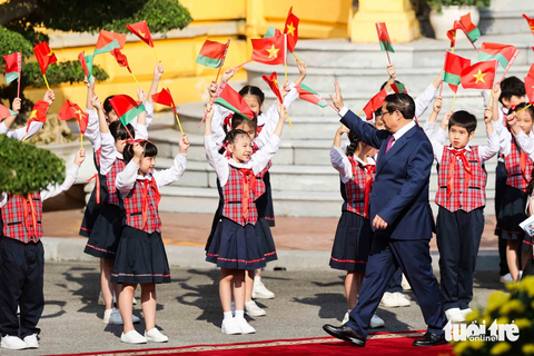 Thủ tướng Phạm Minh Chính đón, hội đàm Thủ tướng Belarus- Ảnh 2. Thủ tướng Phạm Minh Chính vẫy tay chào các em thiếu nhi Hà Nội khi rảo bước trên thảm đỏ, đến nơi đón Thủ tướng Belarus Roman Golovchenko - Ảnh: NGUYỄN KHÁNH