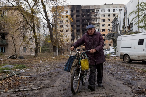 Người dân Ukraine đứng trước một dãy nhà hư hại do giao tranh tại Avdiivka - Ảnh: REUTERS Người dân Ukraine đứng trước một dãy nhà hư hại do giao tranh tại Avdiivka - Ảnh: REUTERS