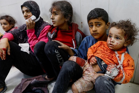 Mỹ bị chỉ trích vì phủ quyết nỗ lực của Liên Hiệp Quốc về ngừng bắn ở Gaza- Ảnh 3. Nhóm phụ nữ và trẻ em Palestine bị thương ngồi trong Bệnh viện Nasser ở Khan Younis, phía nam Gaza - Ảnh: REUTERS