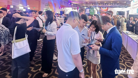 Hàng loạt sàn forex 'núp bóng' tổ chức sự kiện rầm rộ tại TP.HCM- Ảnh 3. Các nhân viên người Việt và người nước ngoài liên tục chào mời khách hàng điền thông tin cá nhân - Ảnh: BÔNG MAI