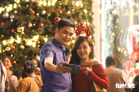 Trung tâm TP.HCM lên đèn rực rỡ, người dân 'lên đồ' xuống phố đón Giáng sinh sớm- Ảnh 4. Chị Quỳnh Anh (quận 7) tranh thủ lưu lại kỷ niệm Giáng sinh sớm cùng người yêu