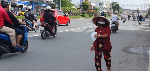 Công ty xổ số lãi kỷ lục, người bán vé số phải xuống đường năn nỉ người mua- Ảnh 2. Người bán vé số xuống cả lòng đường Ba Tháng Hai, quận Ninh Kiều, TP Cần Thơ để bán vé số - Ảnh: LÊ DÂN