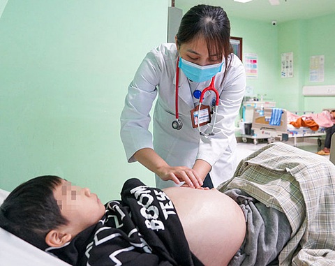 Phát bực với các kiểu 'thần dược', 'lương y' trên mạng - Ảnh 1. Bác sĩ thăm khám cho trẻ gặp biến chứng sau điều trị bệnh bằng thuốc nam mua qua mạng - Ảnh: BVCC