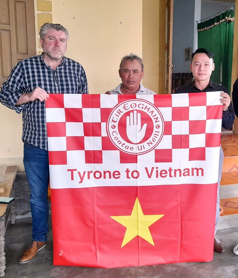 Tài xế John Hurson và lá cờ ông mang đến để sẻ chia với một gia đình ở Nghệ An, thân nhân của một trong 39 người di cư - Ảnh: NVCC Tài xế John Hurson và lá cờ ông mang đến để sẻ chia với một gia đình ở Nghệ An, thân nhân của một trong 39 người di cư - Ảnh: NVCC