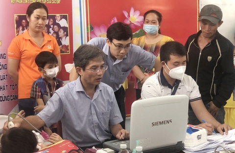 Gầy dựng tinh thần y khoa dấn thân - Ảnh 3. Bác sĩ Đỗ Nguyên Tín (trái) khám tầm soát bệnh tim bẩm sinh cho trẻ em nghèo tại xã Thạch Ngãi, huyện Mỏ Cày Bắc, tỉnh Bến Tre, vào tháng 10-2022 - Ảnh: P.S.