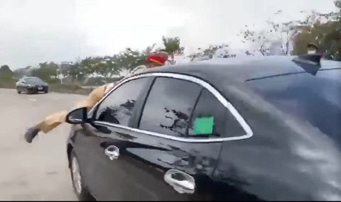 Bắt khẩn cấp tài xế trốn kiểm tra nồng độ cồn, hất cảnh sát giao thông lên nắp capo - Ảnh 1. hiến sĩ Nam đứng ngay phía trước đầu ô tô nên phải bám nắp capo để tránh va chạm - Ảnh: CACC
