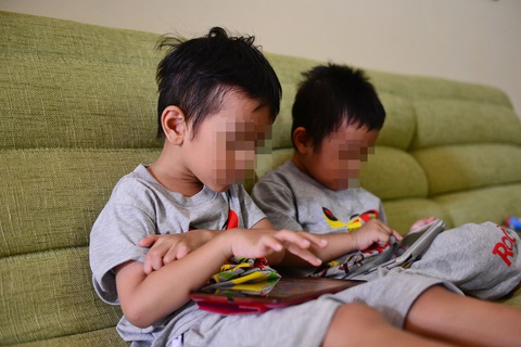 Hai em đang chơi iPad - Ảnh: QUANG ĐỊNH Hai em đang chơi iPad - Ảnh: QUANG ĐỊNH