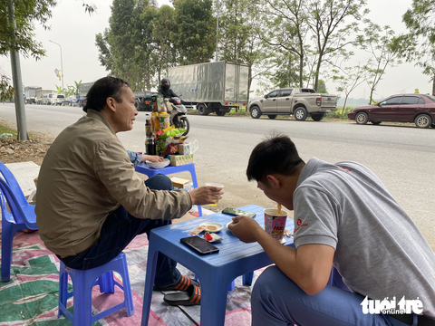 Qúa sốt ruột, nhiều tài xế từ Hà Nội đổ về các tỉnh "ăn trực nằm chờ" để đăng kiểm xe - Ảnh 7. Tài xế Nguyễn Văn Thạo (phải) cùng đồng nghiệp đi đăng kiểm xe của công ty. Anh Thạo cho biết xe anh và đồng nghiệp đã xếp hàng hai ngày, "ở đây không phát phiếu người dân cứ chen lấn nhau, không biết đến bao giờ hết cảnh ăn bờ nằm bụi như thế này", anh Thạo nói - Ảnh: NGUYÊN BẢO