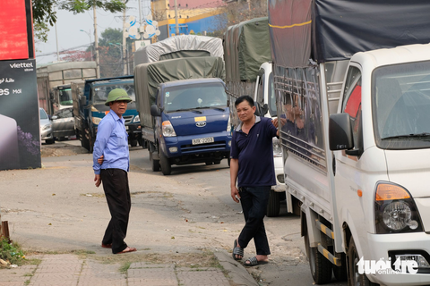 Qúa sốt ruột, nhiều tài xế từ Hà Nội đổ về các tỉnh "ăn trực nằm chờ" để đăng kiểm xe - Ảnh 10. Tài xế Nguyễn Văn Hoàn, Vĩnh Phúc (phải) xếp hàng tại Trung tâm Đăng kiểm 88-01S, Vĩnh Phúc từ sáng 9-3, đến tối muộn 10-3 vẫn chưa được vào khu vực phát số thứ tự làm thủ tục. Một nhân viên tại trung tâm này cho biết, mỗi ngày làm thủ tục đăng kiểm cho gần 200 xe. Số lượng xe đăng ký làm thủ tục đăng kiểm tăng đột biến, khiến trung tâm quá tải. “Để việc đăng kiểm được dễ dàng hơn, xe con và xe tải sẽ xếp thành hai hàng, đăng kiểm chậm đa số ở hàng xe tải do nhiều hạng mục kiểm tra và nhiều xe không đạt”, nhân viên này nói.