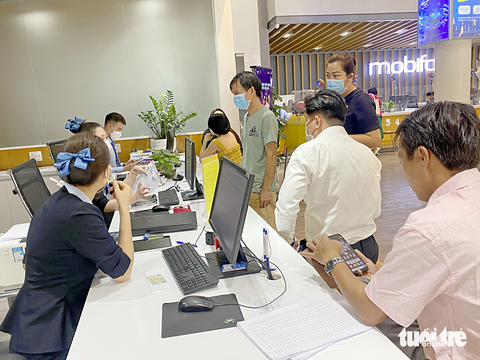 Chuẩn hóa thuê bao di động, người dân được lợi gì? - Ảnh 2. Người dân chờ đợi để cập nhật thông tin thuê bao di động tại một cửa hàng MobiFone ở quận 1, TP.HCM sáng 16-3 - Ảnh: TỰ TRUNG