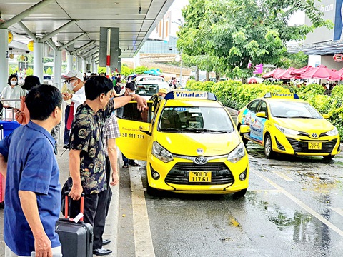 Các hãng taxi đua chiêu mộ tài xế góp xe - Ảnh 1. Hành khách đón taxi tại sân bay Tân Sơn Nhất - Ảnh: C.TRUNG