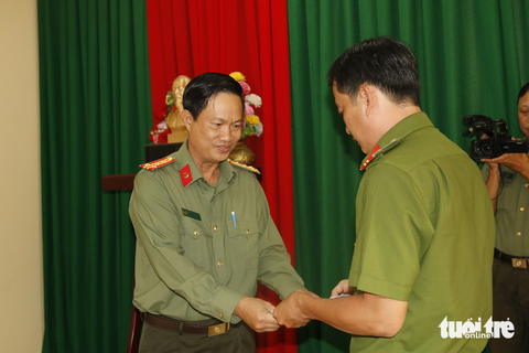 Cảnh sát bị chém 12 nhát vì quay phim nhóm mang hung khí - Ảnh 1. Đại tá Nguyễn Nhật Trường (trái) - phó giám đốc Công an tỉnh An Giang - tặng quà và biểu dương tinh thần dũng cảm của thiếu tá Nguyễn Thành Thi - Ảnh: KIM UYÊN